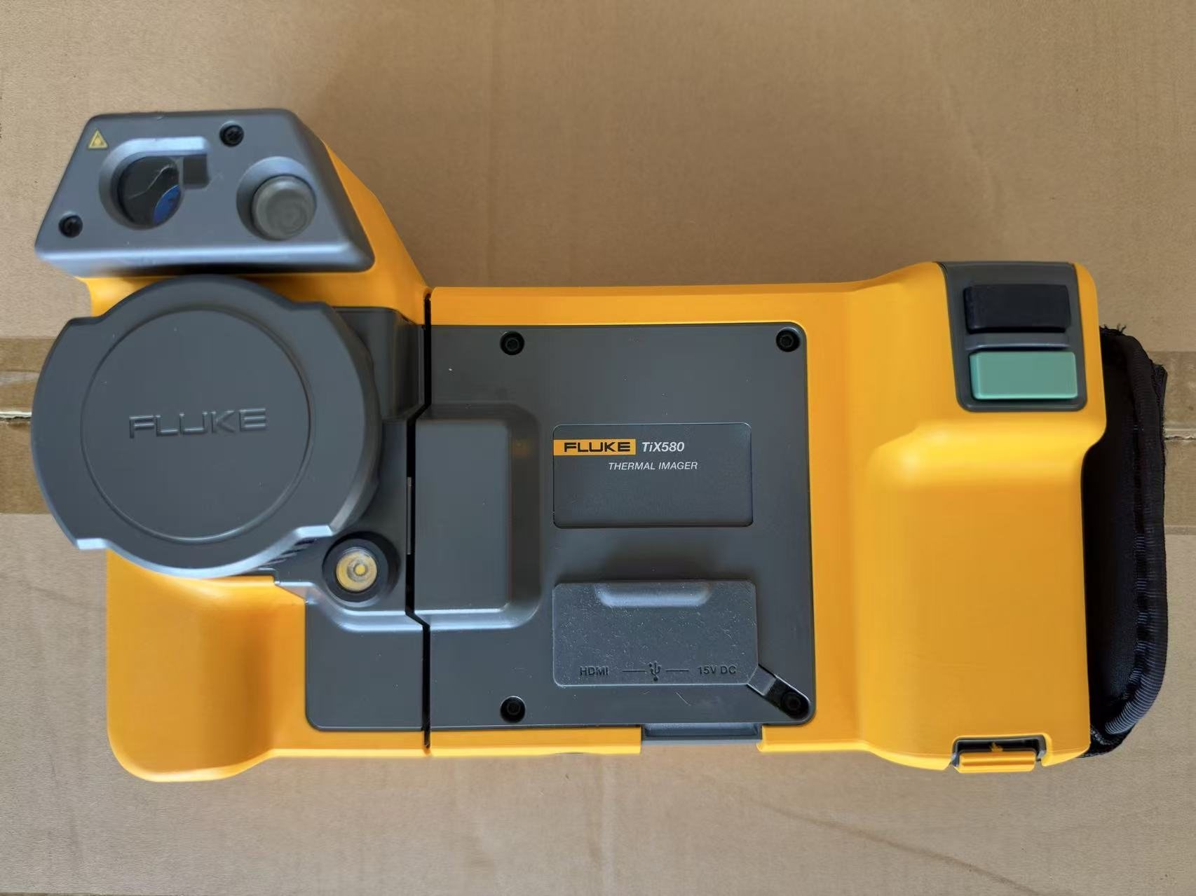 Fluke TiX580 thermal imager from the back: the infrared lens with its cap, the visible-light camera and laser, and the HDMI, USB and 15 V DC ports under a cover