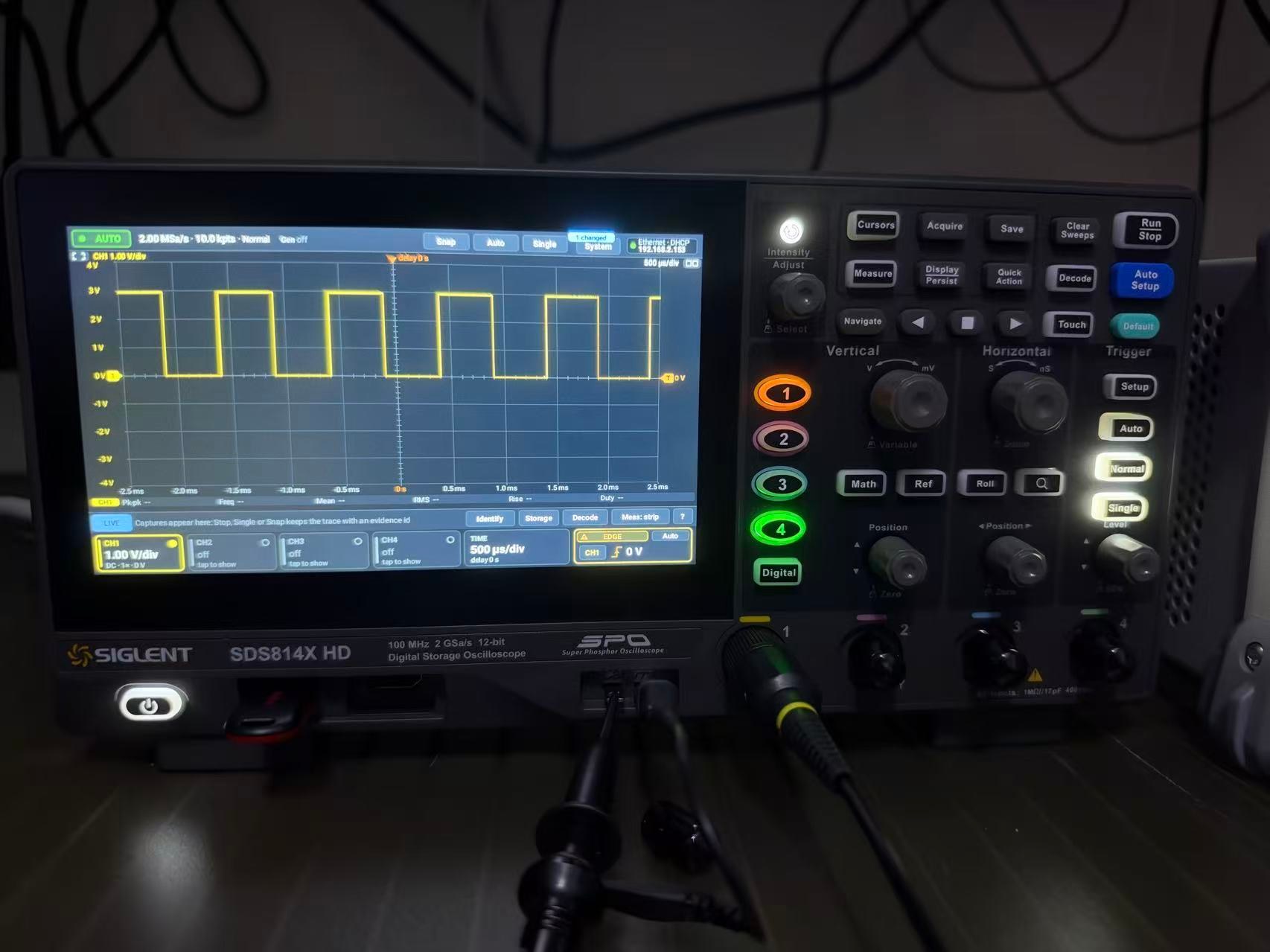 A Siglent SDS814X HD oscilloscope running NovaOS: the NovaOS scope UI on its own touchscreen shows CH1 on the CAL output, a 0 to 3 V, 1 kHz square wave at 1.00 V/div and 500 µs/div